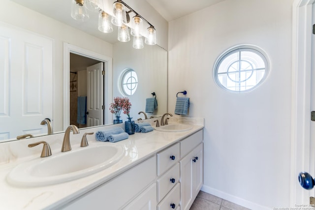 bathroom featuring tile patterned flooring, double vanity, baseboards, and a sink