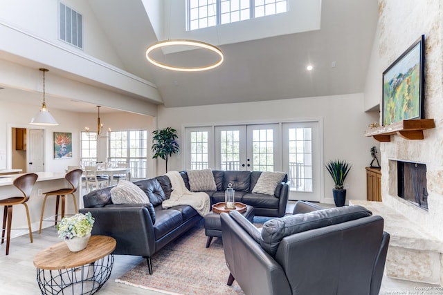 living room featuring visible vents, a healthy amount of sunlight, a fireplace, and french doors