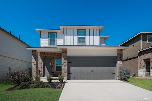 view of front of house featuring a front yard, brick siding, board and batten siding, and driveway