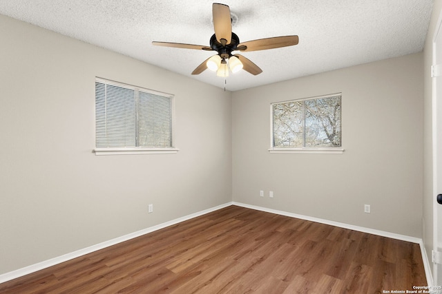 spare room with ceiling fan, baseboards, and wood finished floors