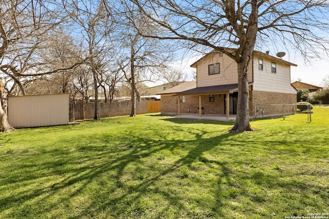 view of yard with an outbuilding, a shed, a patio, and a fenced backyard