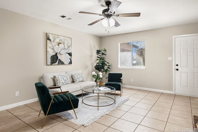 living area featuring light tile patterned floors, visible vents, a ceiling fan, and baseboards