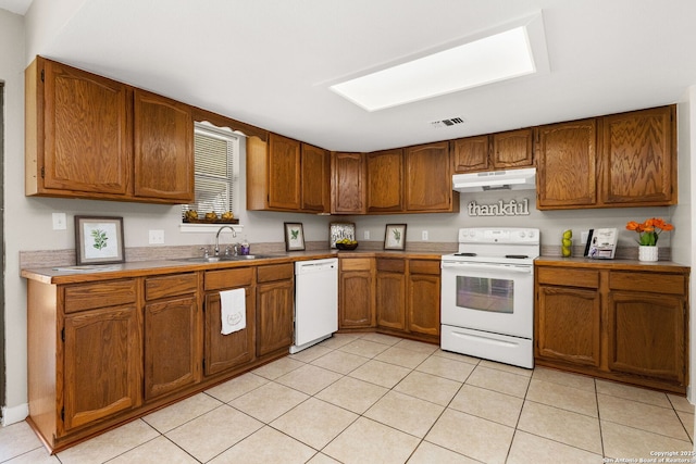 kitchen with white appliances, visible vents, a sink, under cabinet range hood, and brown cabinets