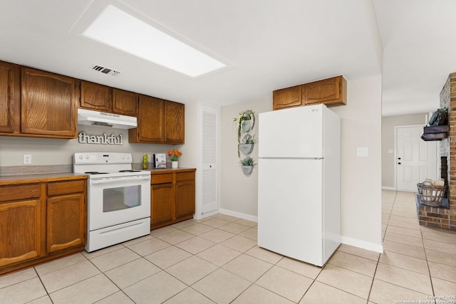 kitchen featuring visible vents, under cabinet range hood, brown cabinets, light tile patterned flooring, and white appliances