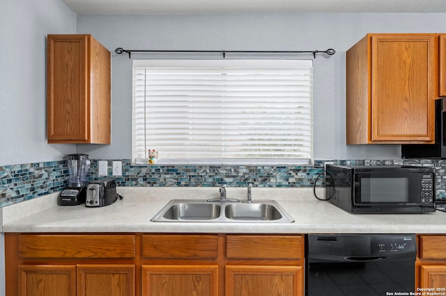 kitchen with black appliances, light countertops, and a sink