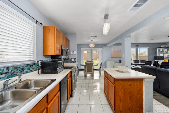 kitchen featuring visible vents, open floor plan, light countertops, black appliances, and a sink