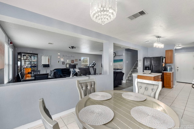 dining room featuring visible vents, stairs, light tile patterned floors, a notable chandelier, and a textured ceiling