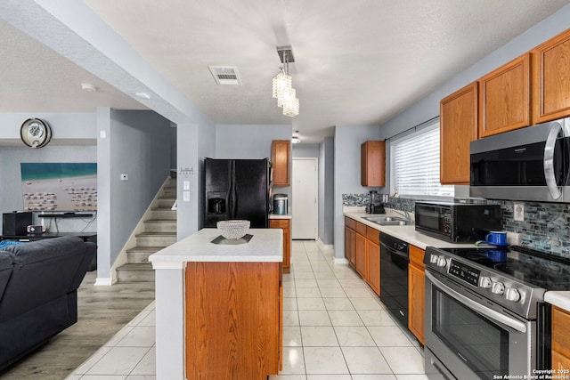 kitchen with a sink, black appliances, light countertops, open floor plan, and a center island