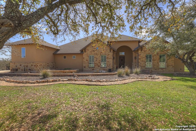 view of front of house with stone siding, stucco siding, and a front lawn