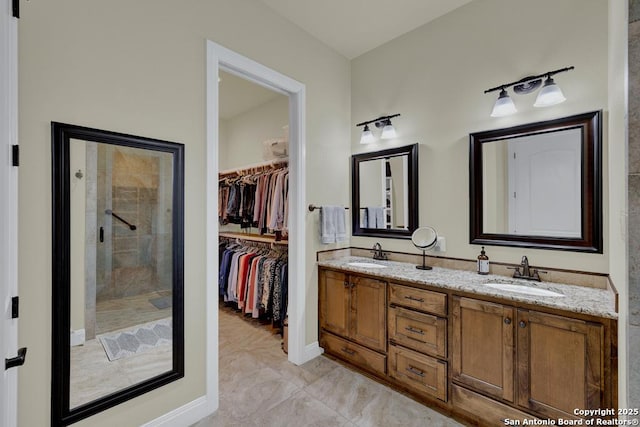 full bathroom featuring double vanity, a spacious closet, a stall shower, and a sink