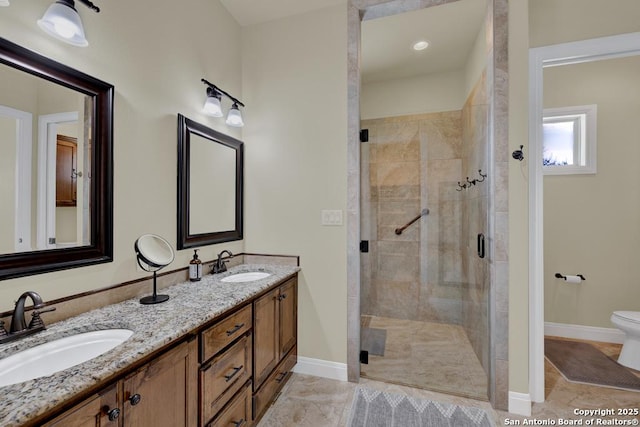 bathroom with a sink, baseboards, toilet, and a stall shower