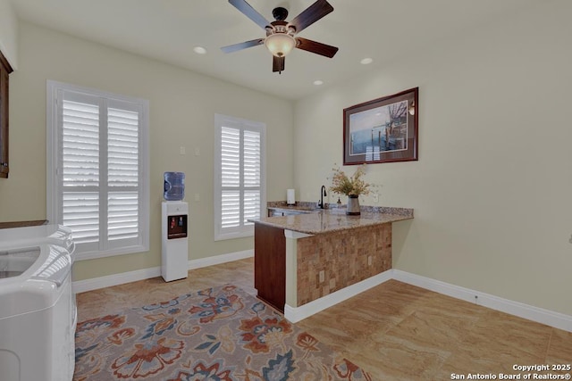 office area featuring baseboards, washing machine and clothes dryer, recessed lighting, ceiling fan, and a sink