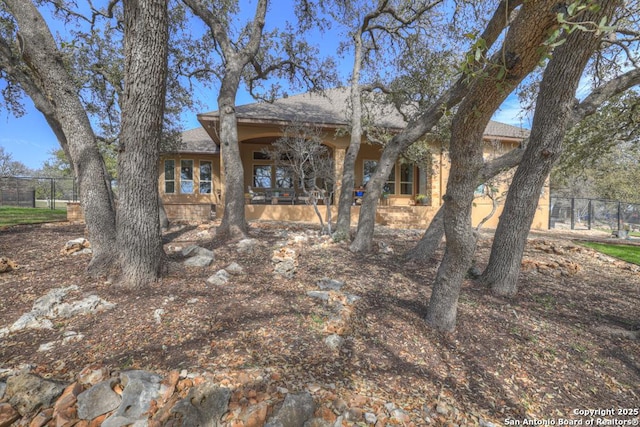 view of front of house with roof with shingles and fence