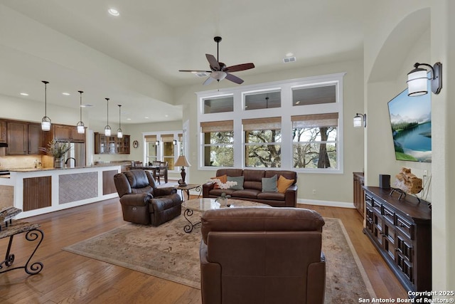 living room featuring hardwood / wood-style flooring, recessed lighting, a ceiling fan, and visible vents