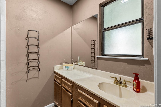 bathroom with vanity and a textured wall