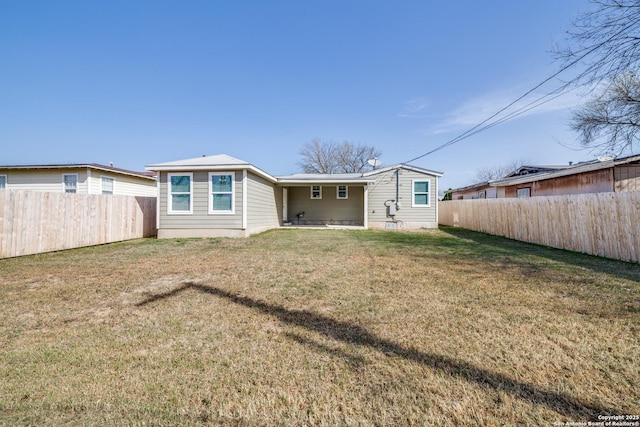 back of property featuring a lawn and a fenced backyard