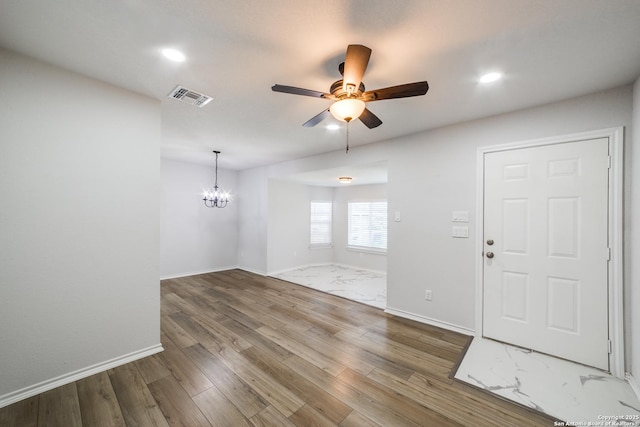 interior space with wood finished floors, visible vents, baseboards, recessed lighting, and ceiling fan with notable chandelier