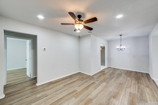 unfurnished room with light wood finished floors, visible vents, ceiling fan with notable chandelier, and baseboards