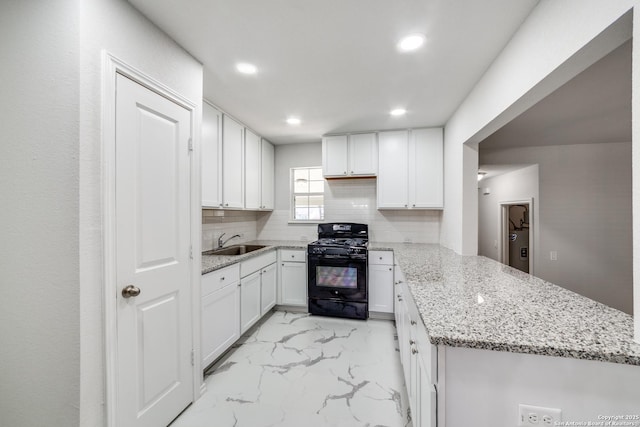 kitchen with a peninsula, a sink, decorative backsplash, black range with gas stovetop, and marble finish floor