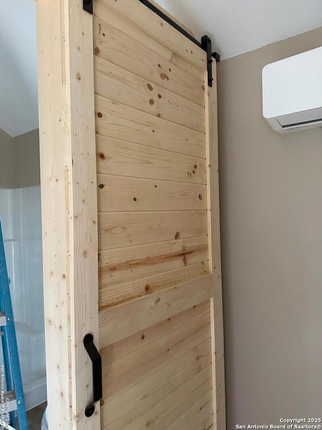 details with a barn door and a wall mounted air conditioner