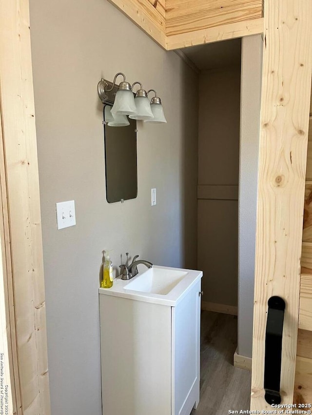 bathroom with a sink, baseboards, and wood finished floors