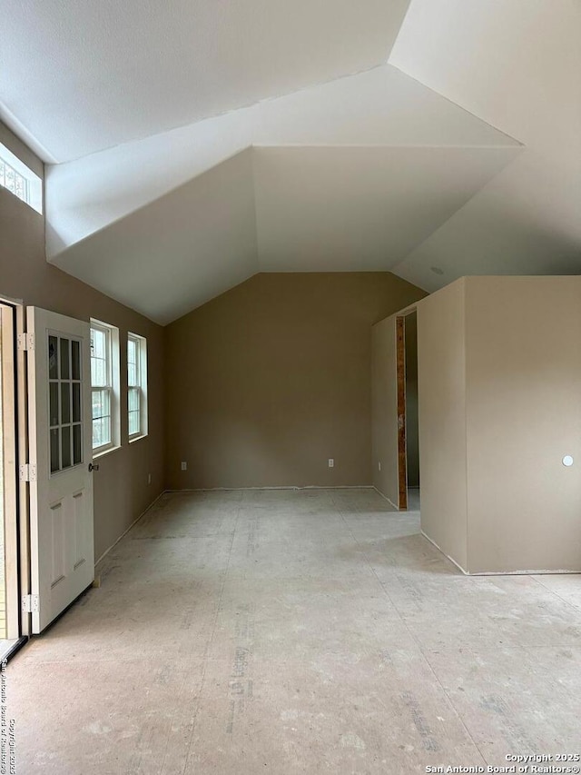 additional living space featuring vaulted ceiling and plenty of natural light