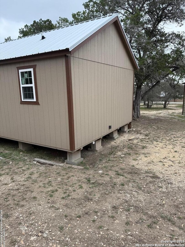 view of property exterior with an outdoor structure and metal roof