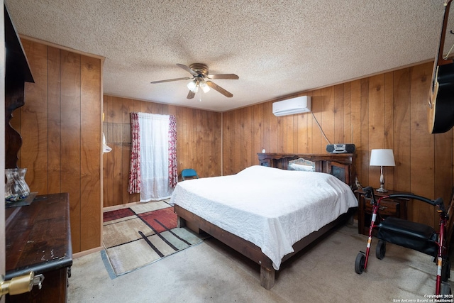 carpeted bedroom with wooden walls, a textured ceiling, a wall mounted air conditioner, and ceiling fan