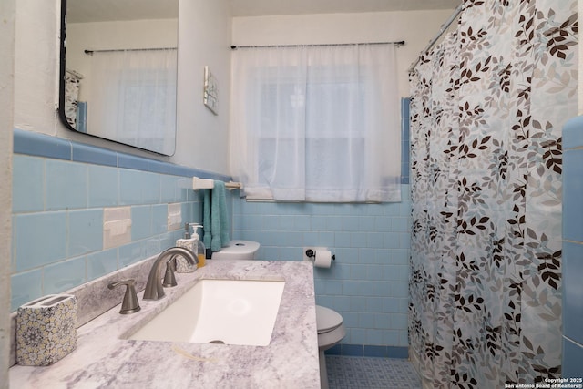 full bath featuring curtained shower, tile walls, toilet, tile patterned floors, and vanity