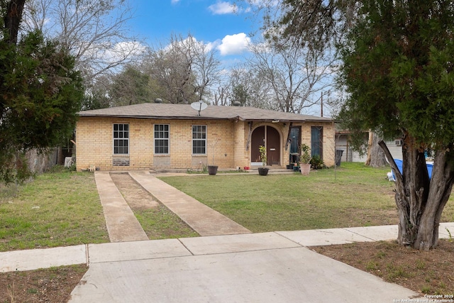 ranch-style home featuring brick siding, a front lawn, and fence