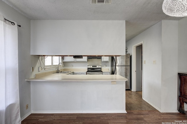 kitchen featuring a peninsula, light countertops, appliances with stainless steel finishes, and a sink