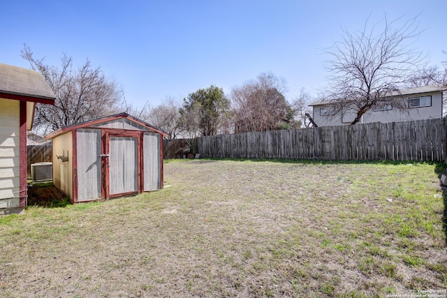 view of yard with an outbuilding, central AC, a storage unit, and a fenced backyard