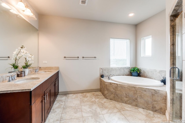 bathroom featuring tile patterned floors, a bath, visible vents, and a sink