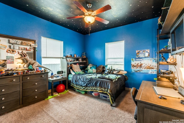 bedroom with multiple windows, a ceiling fan, and carpet floors