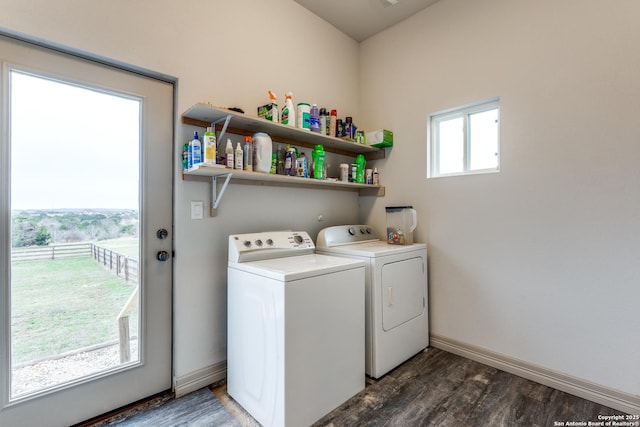 clothes washing area featuring laundry area, wood finished floors, washing machine and dryer, and baseboards