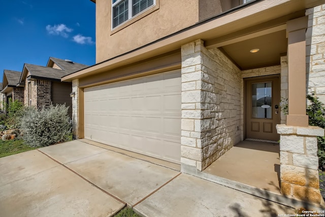 exterior space featuring concrete driveway, a garage, stone siding, and stucco siding