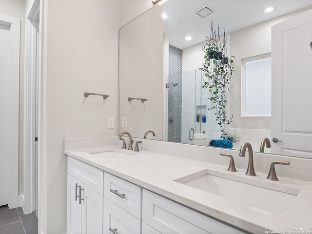 bathroom with double vanity, a stall shower, and a sink