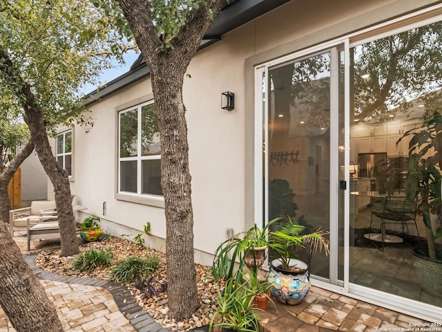 property entrance with stucco siding and a patio area