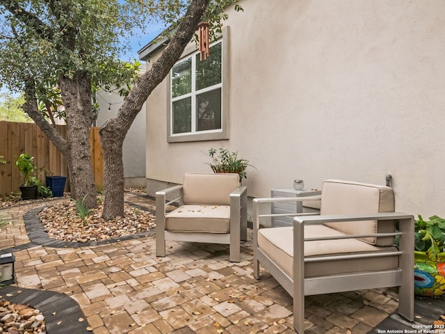 view of patio featuring an outdoor living space and fence