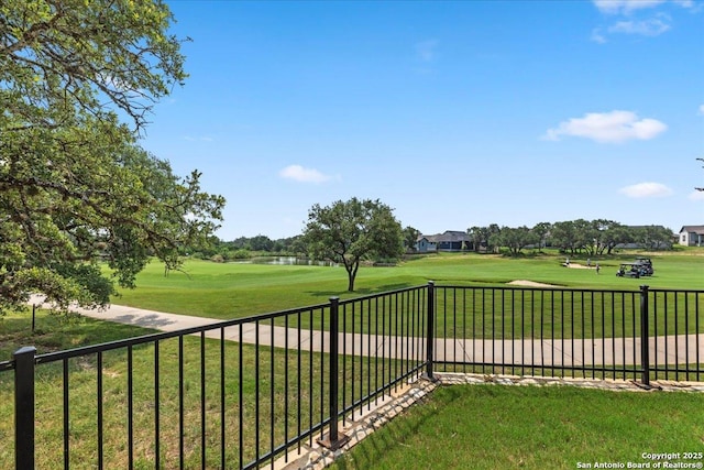 view of yard featuring view of golf course and fence