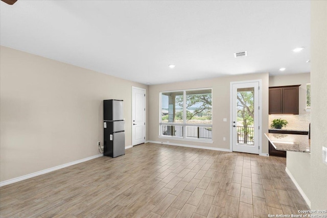 unfurnished living room featuring recessed lighting, visible vents, baseboards, and light wood-style floors