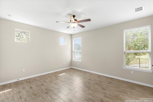 unfurnished room with ceiling fan, baseboards, visible vents, and light wood-type flooring