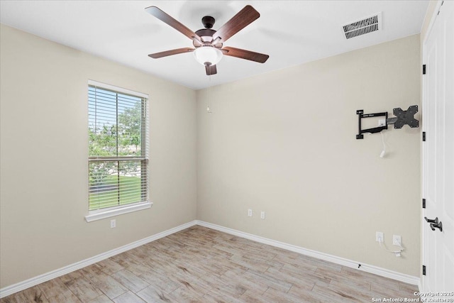 empty room featuring light wood-type flooring, visible vents, baseboards, and ceiling fan