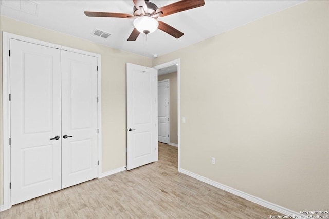 unfurnished bedroom featuring visible vents, a ceiling fan, a closet, light wood finished floors, and baseboards