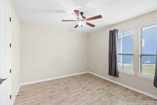 unfurnished room featuring baseboards, light wood-style floors, and a ceiling fan