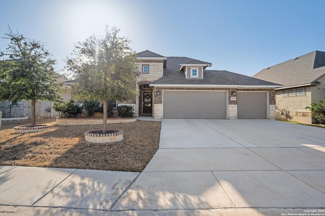 view of front facade with concrete driveway, a garage, stone siding, and roof with shingles