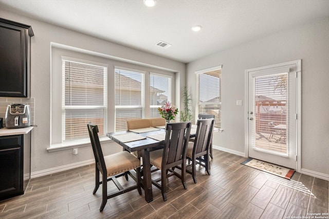 dining space with visible vents, a healthy amount of sunlight, baseboards, and wood finish floors