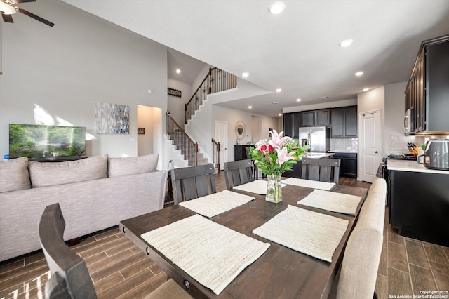 dining space featuring stairs, ceiling fan, recessed lighting, and wood tiled floor