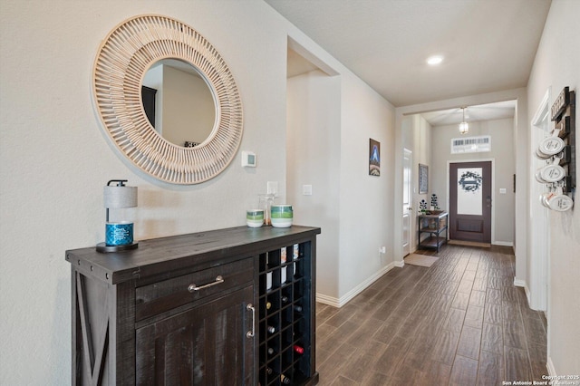 entrance foyer with dark wood-type flooring and baseboards