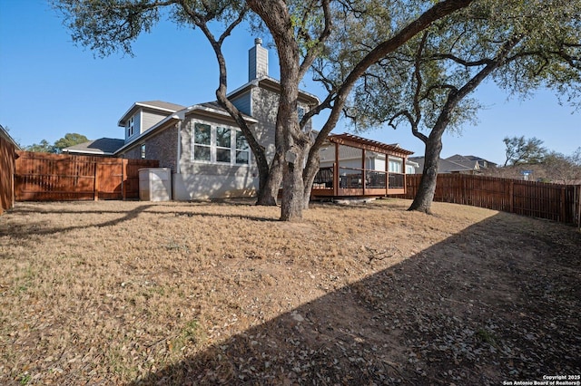 back of property featuring a chimney, a pergola, and a fenced backyard